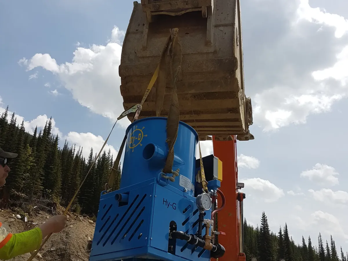 Hy-G P12 concentrator set up outdoors with a mine and forest backdrop.