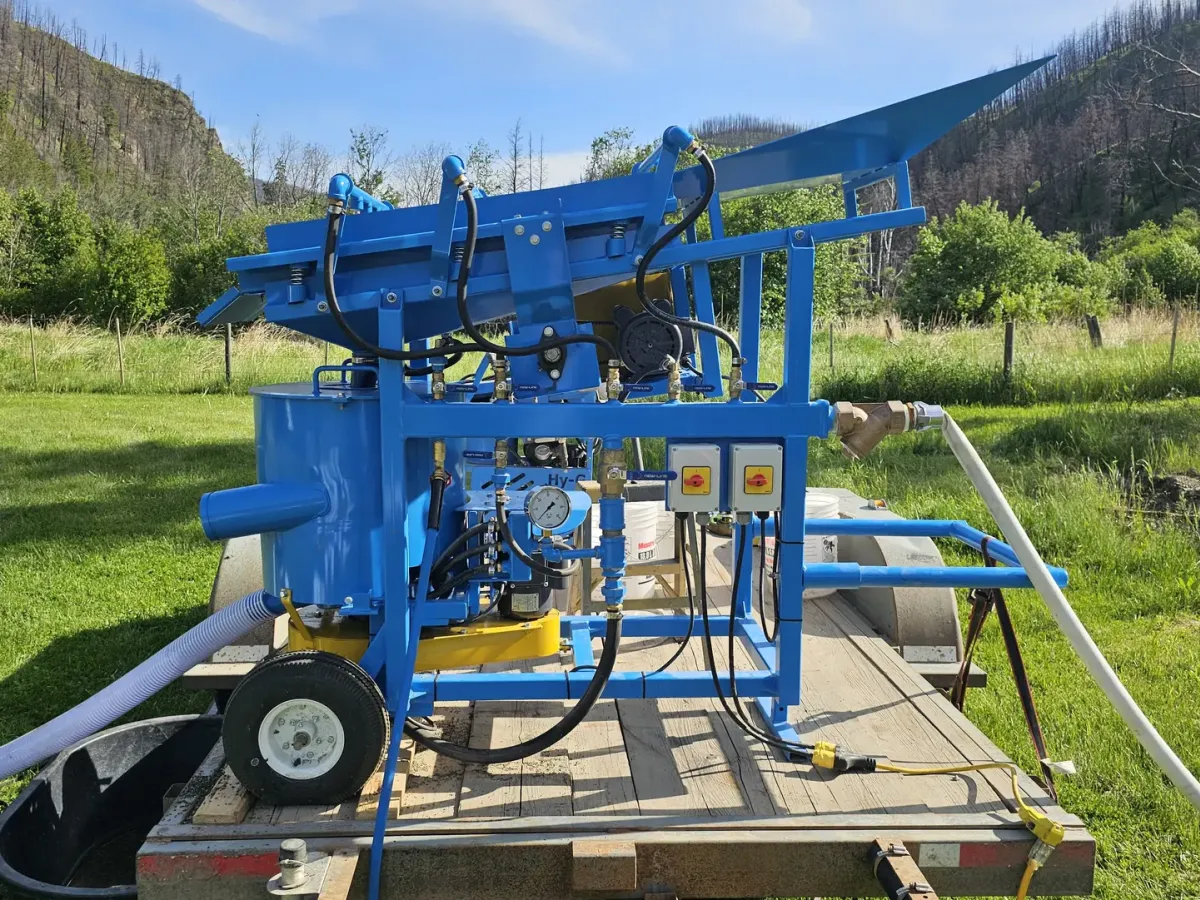Hy-G P12T wash-plant setup outdoors on grass with mountains behind.